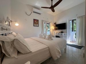 a bedroom with a large bed and a ceiling fan at Oceanic - Luxury Boutique Hotel in Palolem