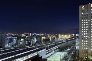 a view of a city at night with a clock tower at Courtyard by Marriott Shin-Osaka Station in Osaka