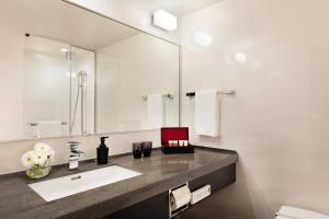 a bathroom with a sink and a mirror at Courtyard by Marriott Shin-Osaka Station in Osaka