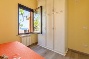 sypialnia z dużym oknem i łóżkiem w obiekcie Villetta Residence Porto Corallo w mieście Villaputzu
