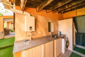 kuchnia ze zlewem i pralką w obiekcie Villetta Residence Porto Corallo w mieście Villaputzu