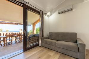 salon z kanapą i balkonem w obiekcie Villetta Residence Porto Corallo w mieście Villaputzu +28 zdjęć