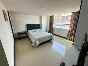 a bedroom with a bed and a large window at Apto 401 / Av. Las Lajas in Ipiales