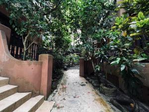 a garden with trees and stairs next to a building at Ombak Dive Resort Perhentian Island in Perhentian Islands