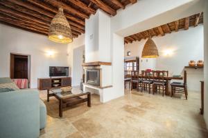 a living room with a fireplace and a dining room at Can Pla Roig con vistas al Mar y la Puesta de Sol in Sant Joan de Labritja