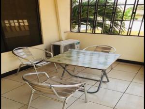 a table and chairs in a room with a microwave at Double Room With Balcony in the heart of Accra in Accra