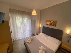 a bedroom with a bed with two towels on it at Hotel Ausonia in Rimini