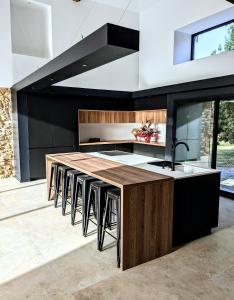 cocina con encimera con fregadero y taburetes en Villa Laurca, en Auch
