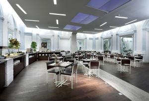 a restaurant with tables and chairs in a room at Exe International Palace in Rome