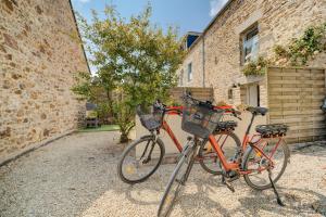 two bikes are parked next to a brick building at La petite Hautière in Plouër-sur-Rance