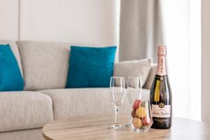 a bottle of champagne and two wine glasses on a table at Le Bastille By Sweett in Paris