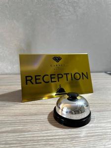 a silver bell on a table next to a box at Garnet hotel in Bishkek
