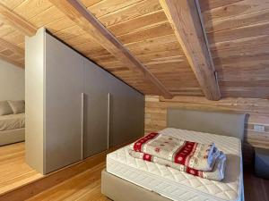 un letto in una stanza con soffitto in legno di Alpi Azzurre a Limone Piemonte