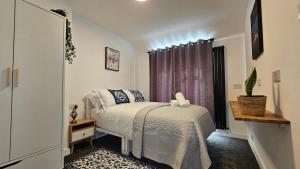 Un dormitorio pequeño con una cama y una ventana. en EcuaStay New Luxurious 4 Bedroom Home with Garden and parking, en Dagenham