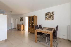 a dining room with a wooden table and chairs at Seetraum HdK 68 in Döse