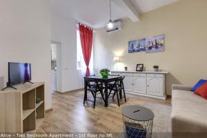 una sala de estar con una mesa y un sofá en Alice & Ellen Apartments by Mamo Florence, en Florencia