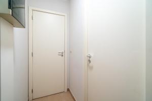 una porta bianca in una stanza con una parete bianca di Le Cosy Miramar appartement a Blankenberge