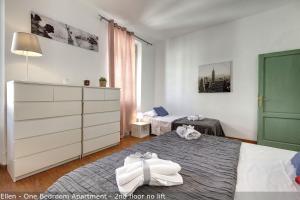 1 dormitorio pequeño con 2 camas y vestidor en Alice & Ellen Apartments by Mamo Florence, en Florencia