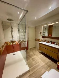 ein Badezimmer mit Glasdusche und zwei Waschbecken in der Unterkunft Maison "L'oeil du Prince" - Verdun Centre - Terrasse - Wifi - 7 couchages - 10 personnes - Garage Vélo et moto - Géré par PrestaZen'Services in Verdun-sur-Meuse + 35 Fotos