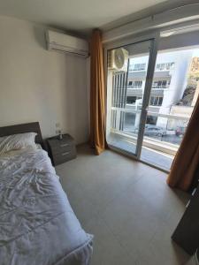 une chambre avec un lit et une grande fenêtre dans l'établissement Prime Area 1 Bed Apt St Julians, à San Ġiljan