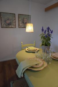 ein Esstisch mit einer Lampe und ein grüner Tisch mit in der Unterkunft O lar da praia in Corcubión