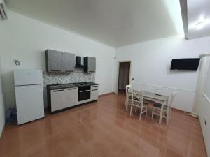 a kitchen with a stove and a table with chairs at A casa di Picci in Avola
