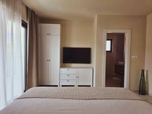 a bedroom with a bed and a flat screen tv at Villa Artemis II in Žman