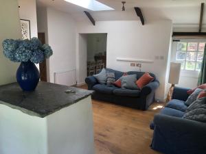 a living room with a vase of flowers on a counter at Wisteria Cottage in Truro
