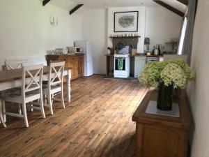 a kitchen with a table with a vase of flowers at Wisteria Cottage in Truro