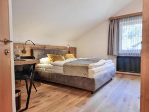a bedroom with a bed and a desk in it at Belmonte Tirol - Boutique Hotel in Sillian +42 photos