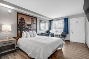 Un dormitorio con una gran cama blanca y un escritorio. en Executive Lodge, en Portland