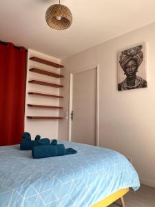 a bedroom with a blue bed with a statue on the wall at La Royauté à 22 min de Disneyland et Center parcs in Meaux
