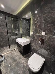 a bathroom with a toilet and a sink and a shower at Seas Hotel Amman in Amman
