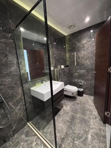 a bathroom with a sink and a shower and a toilet at Seas Hotel Amman in Amman