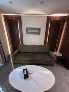 a living room with a couch and a table at Seas Hotel Amman in Amman