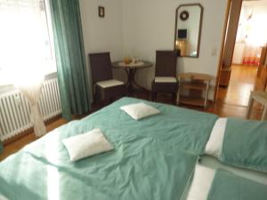 ein Schlafzimmer mit einem grünen Bett mit zwei Kissen darauf in der Unterkunft Ferienwohnung Toska in Pfaffenweiler