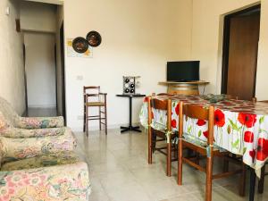 a living room with a couch and a table with chairs at CASA VACANZA PALMENTO BELLA in Santa Maria Del Focallo