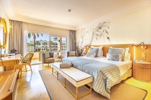 a bedroom with a large bed and a living room at Grupotel Parc Natural & Spa in Playa de Muro +37 photos