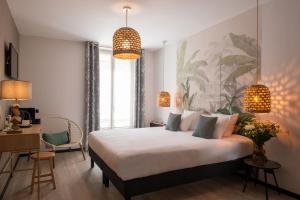 a bedroom with a large bed and a desk and a desk at Helussi H&ocirc;tel in Paris