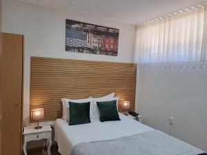 a bedroom with a large bed with a wooden headboard at Hotel SQUARE in Sertã