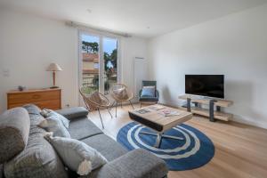 a living room with a couch and a table at Maison et jardin, 600m de la mer, St Brevin in Mindin