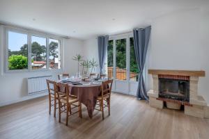 a dining room with a table and a fireplace at Maison et jardin, 600m de la mer, St Brevin in Mindin