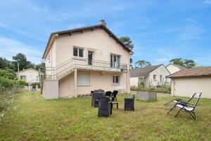 a house with chairs in front of it at Maison et jardin, 600m de la mer, St Brevin in Mindin