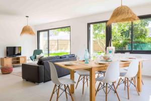 a living room with a table and a couch at À 490m de la plage, maison neuve pour 8 in Trébérouant