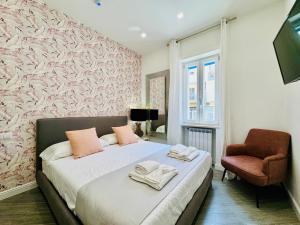 a bedroom with a bed and a chair at YourHome - Santa Lucia Rooms in Sorrento