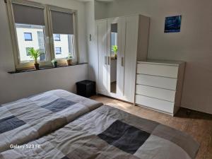 a bedroom with a bed and a dresser and windows at Apartment Bochum in Bochum