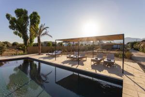 ein Swimmingpool mit zwei Liegestühlen und einem Pavillon in der Unterkunft Villa Calamare - IsulaTravel in Avola