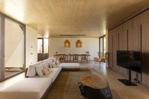 ein Wohnzimmer mit einer weißen Couch und einem Tisch in der Unterkunft Villa Calamare - IsulaTravel in Avola