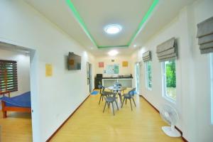 ein Flur mit einem Tisch und Stühlen in einem Zimmer in der Unterkunft BaansuanThanisorn&Rolf บ้านสวนธนิสร & ร๊อฟ in Ban Nam Pen