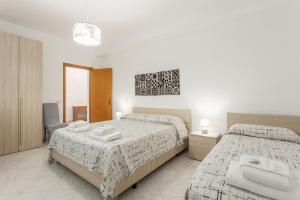 a bedroom with two beds with towels on them at Contessa Vacanze Byron in Contessa Entellina